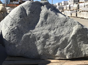 A large grey landscape boulder sitting in the sun
